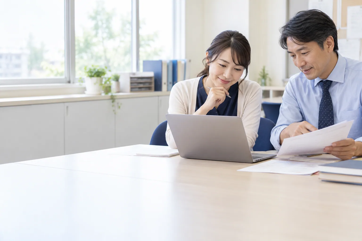 AI-generated illustration of teachers reviewing a laptop and training materials